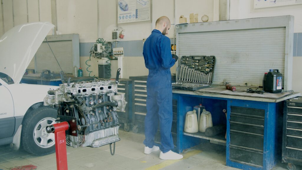 A Man in Blue Coverall Choosing a Hand Tool